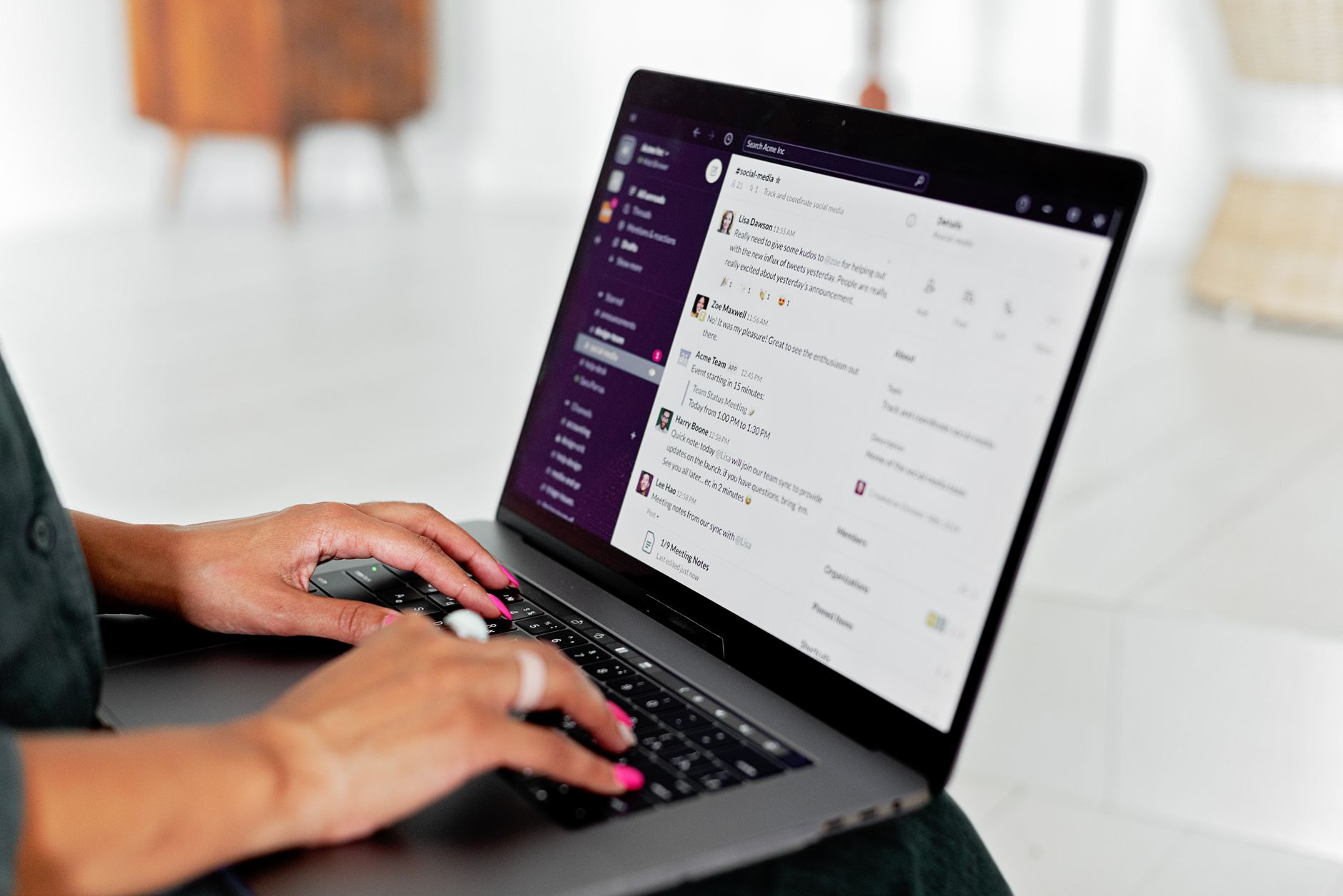 A freelancer reviewing email on a laptop at a clean desk with a notebook nearby